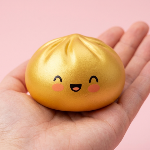 Dumpling Squishy Złoty Lucky w dłoni — porównanie rozmiaru