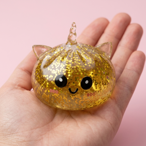 Dumpling Squishy Jednorożec Glitter Złoty w dłoni — porównanie rozmiaru